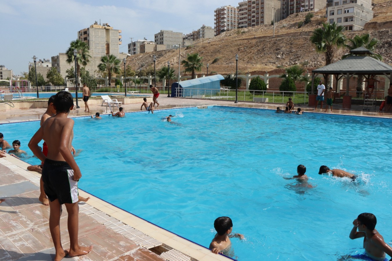 Urfa’da gençler belediyenin havuzunda serinledi
